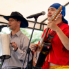 Imagen de dos hombres con trajes típicos tocando música colombiana.