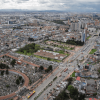 Vista aérea de Bogotá con alta densidad de edificaciones, una importante avenida en primer plano, el Cementerio Central visible en la parte inferior izquierda.