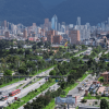 Vista panorámica de Bogotá con corredores viales, amplias zonas verdes, edificaciones residenciales y comerciales, y cerros orientales al fondo.