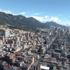Vista panorámica de Bogotá con edificaciones, corredores viales y cerros orientales bajo cielo despejado.