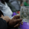 Persona sostiene una tarjeta ilustrada de la Ruta Viva del Territorio con flora, fauna y estaciones ambientales.