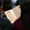 Imagen de personas de espaldas leyendo un folleto de escrituras de Bogotá
