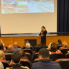 Foto de una mujer hablando en un auditorio 
