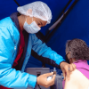 Foto que muestra un enfermero colocando una vacuna en un brazo de una mujer