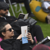 Imagen de hombres sentados en sillones al aire libre con libros abiertos.