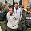 Foto de dos de los capturados junto a hombres de la Policía.