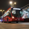 Foto de una estación y un bus de TransMilenio con iluminación de alumbrado público en Bogotá.