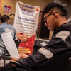 Joven con su hoja de vida en una feria de empleo en Bogotá