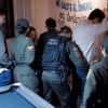 Operativo de seguridad en espacio interior con varios uniformados frente a un mural informativo durante una acción de prevención de delitos en el barrio San Diego.