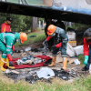 Personal operativo recoge residuos, textiles y otros elementos retirados de una ocupación informal bajo un puente, en una zona verde del humedal Tingua Azul.