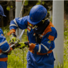 Imagen de dos técnicos de ENEL haciendo mantenimiento a unos cables de luz.