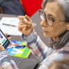 Mujer sentada frente a un computador portátil. 
