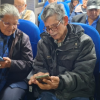 Foto de dos adultos mayores mirando la pantalla de sus celulares 