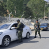 Militares en un retén militar a dos carros.