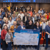 Grupo de personas reunidas en un auditorio con sillas rojas. En el centro de la imagen varias personas sostienen un tablero gigante con el texto: “Acuerdo de conservación. El agua que nos une”, junto a múltiples firmas