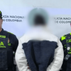 Hombre capturado, de espaldas, en medio de dos policías.