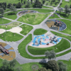 Vista aérea de un parque con amplias zonas verdes, senderos peatonales curvos y varias áreas de juegos infantiles distribuidas alrededor de una plazoleta central. Se observan estructuras de juego de diferentes tamaños, superficies de colores y árboles rodeando el espacio recreativo.