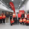 Grupo de deportistas del Equipo Bogotá, junto a personal de apoyo, posan para una fotografía en el hall interior de un edificio. Varias personas visten chaquetas deportivas en tonos rojo, amarillo y blanco.