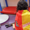 Foto que muestra un niño sentado con una bandera de Bogotá en la espalda