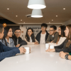 Foto que muestra un grupo de personas sentadas hablando
