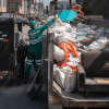 Foto que muestra personas colocando residuos en un ecopunto 
