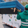 Foto que muestra dos personas dejando un mueble en un Ecopunto