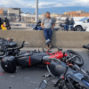 Motocicletas involucradas en un choque permanecen sobre la calzada de una vía principal de Bogotá. En el lugar se observan varias motocicletas caídas, fragmentos dispersos sobre el pavimento y vehículos circulando por los carriles contiguos.