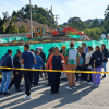 Personas reunidas en una vía observan una situación de movilidad delimitada con cinta amarilla. En el lugar se ven vehículos detenidos, carpas blancas y banderines de colores.