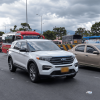 Vehículos particulares, motocicletas y buses circulan por una vía de varios carriles en Bogotá bajo un cielo nublado.