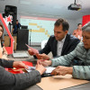 Foto que muestra personas firmando documentos 