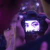 Imagen de una cámara fotográfica en cuyo lente se ven los ojos de una mujer