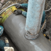Foto que muestra dos personas del Acueducto de Bogotá reparando una tubería