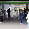 Foto de personas ingresando a una estación de TransMilenio usando su tarjeta para validar el pasaje.