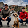 Foto de dos funcionarios con un perro cafe con blanco 