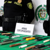 Foto que muestra dos policías y armas cortopunzantes en una mesa