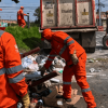 Foto que muestra dos personas con el uniforme de Aguas Bogotá levantando residuos 