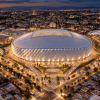 Vista aérea nocturna del diseño del nuevo estadio El Campín, con cubierta retráctil iluminada y entorno urbano circundante.