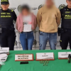 Dos personas capturadas en medio de dos policías. 