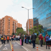 Personas reunidas en un espacio público junto a edificios de Bogotá durante una actividad de simulacro de evacuación. Varias personas permanecen organizadas sobre la vía, delimitada con conos de tránsito, mientras personal de apoyo coordina la jornada.