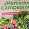 Productos agrícolas frescos, entre ellos rábanos, remolachas, lechugas y otras hortalizas, exhibidos en un puesto de Mercados Campesinos Bogotanos