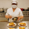 Una señora preparando alimentos en un comedor comunitario