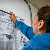 Mujer consultando un cartel con la ruta de atención a mujeres.