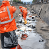 Foto que muestra personas limpiando un canal de agua 