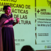 Imagen de una mujer hablando por un micrófono en una tarima 