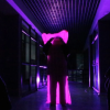 Imagen de tres personas en un corredor oscuro.