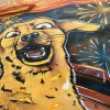 Foto de un mural o pintura de un perro, con un fondo de show pirotécnico.