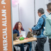 Dos hombres en una feria de empleo junto a una funcionaria de la Secretaría Distrital de Desarrollo Económico