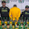Foto el hombre captutado con las botellas de licor adulterado junto a uniformados de la Policía de Bogotá.