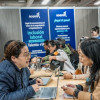 Ciudadana en una feria de empleo en Bogotá junto a una funcionaria de la Secretaría Distrital del Desarrollo Económico