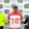 Foto de un hombre capturado en medio de dos policías.